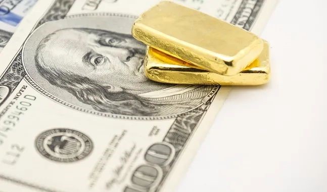 two gold bars are sitting on USD, which is attractive to traders