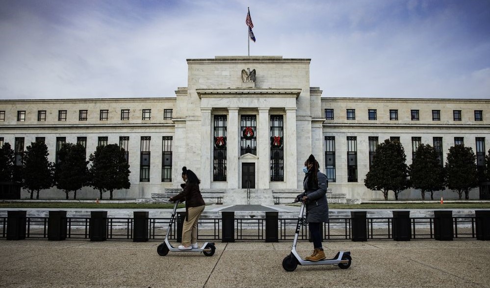Two people is playing skateboard in front of the FED in US